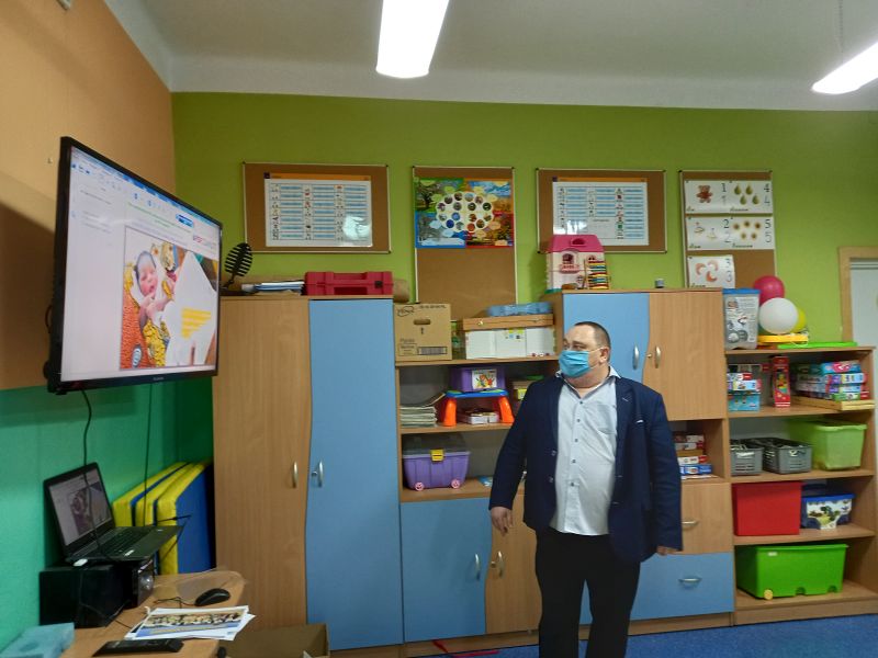 Zdjęcie przedstawia dyrektora biblioteki stojącego przy tablicy interaktywnej w klasie