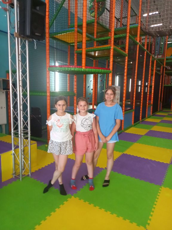 Zdjęcie przedstawia trzy dziewczynki stojące w Parku Rozrywki