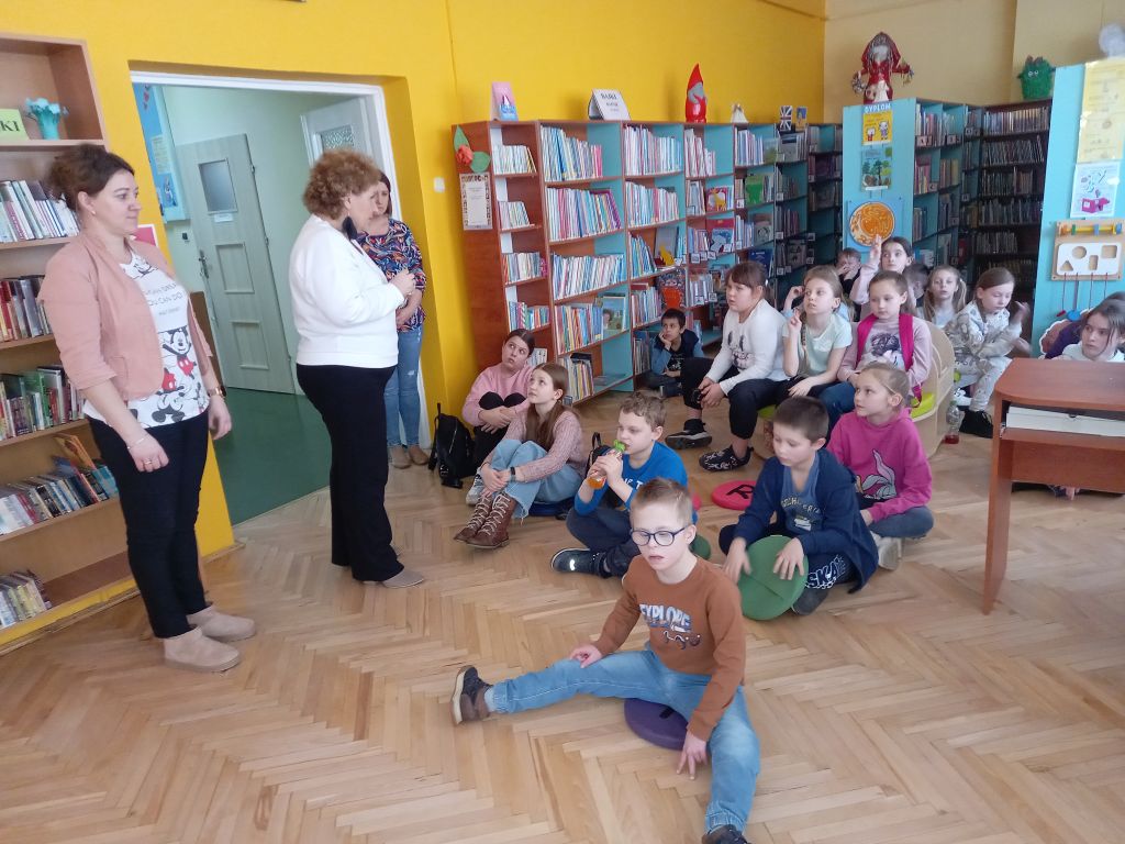 Zdjęcie przedstawia grupkę dzieci i pracowników Biblioteki w Rypinie w trakcie zajęć w bibliotece