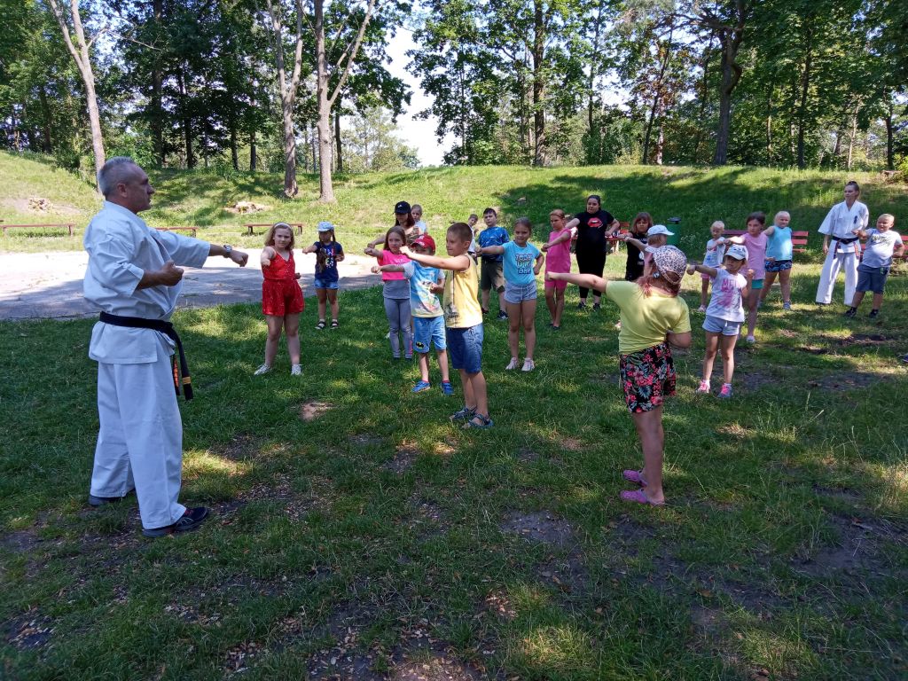 dzieci i mistrz Karate Paweł Olszewski w trakcie treningu i lekcji karate na skępskim Okopie. Dzieci wykonują ćwiczenia