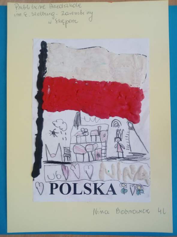 Fotografia przedstawia pracę laureatki trzeciego miejsca Niny Bobrowicz w kategorii wiekowej do 6 lat. Na ilustracji widoczna jest flaga Polski wyklejona z plasteliny na kartce, na  tle białym . Pod flagą jest napis Polska oraz narysowane domki i imię autorki.