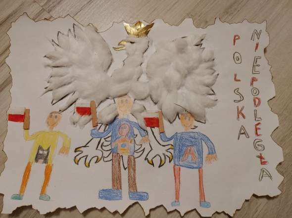 Fotografia przedstawia pracę laureata wyróżnienia Wiktora Wszelaka w kategorii wiekowej do 6 lat. Na ilustracji widoczna jest narysowana grupka dzieci z flagami w rękach - rysunek dzieci umieszczony pod obrazkiem orła w koronie wykonanego z wyklejonych piór. Z prawego boku napis Polska Niepodległa  