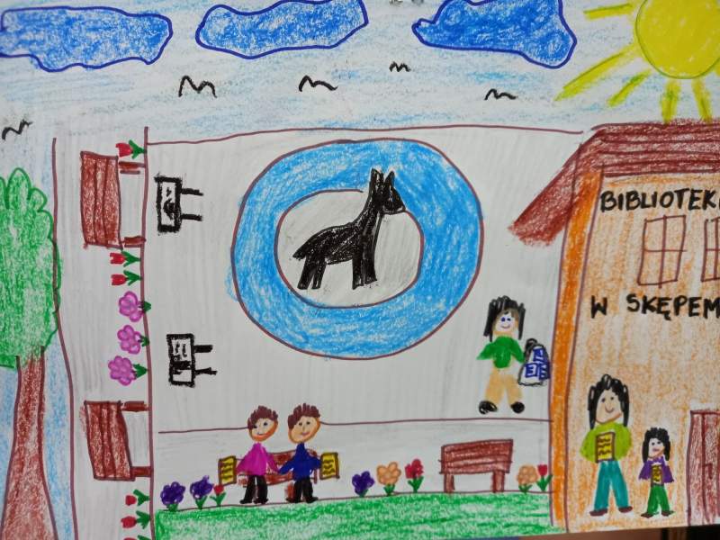 Zdjęcie przedstawia prace wykonana kredkami. Na rysunku są dzieci idące do biblioteki. W tle jest fontanna z koziołkiem, ławeczki i słońce na błękitnym niebie