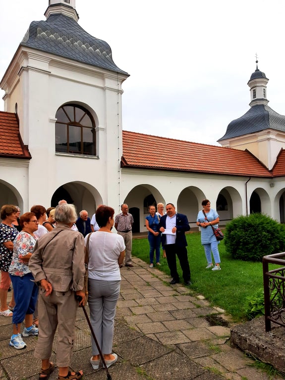 Na zdjęciu widać uczestników wycieczki stojących na krużgankach w skępskim klasztorze wraz z dyrektorem biblioteki