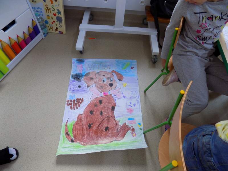 Na zdjęciu widać pracę plastyczną w postaci pokolorowanego rysunku psa na dużym formacie papieru