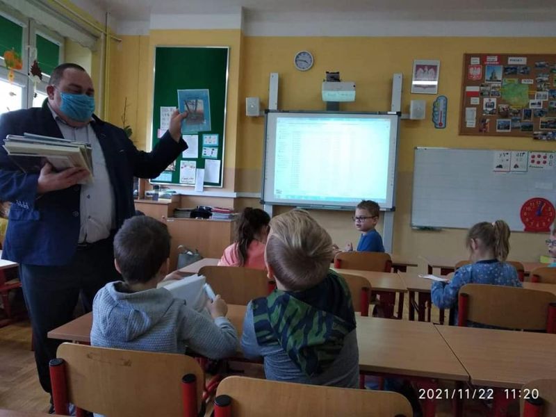 Zdjęcie przedstawia dyrektora Biblioteki prezentującego uczniom książki o Skępem w trakcie lekcji