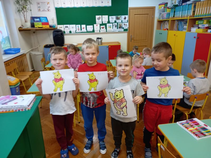 Czwóka przedszkolaków prezentują rysunki