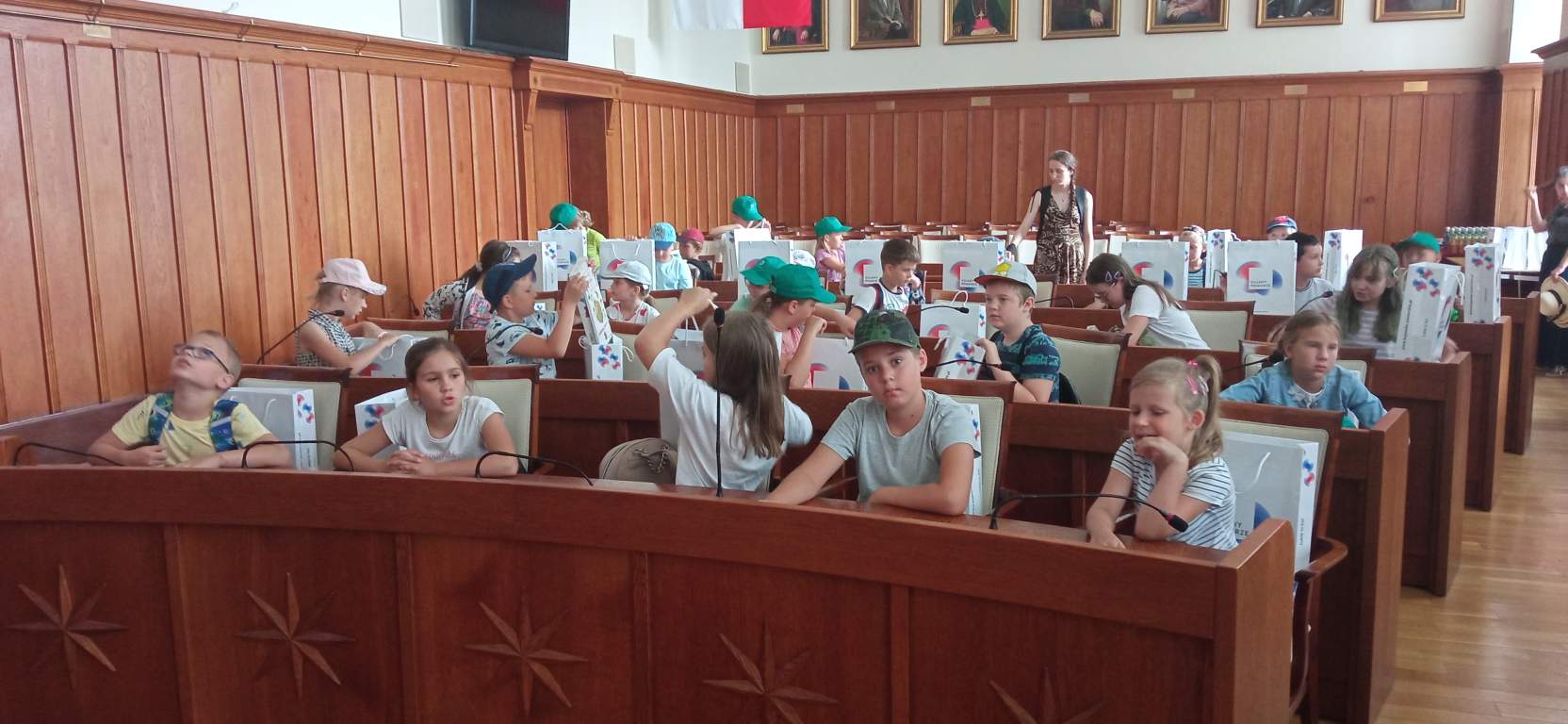 Fotografia przedstawia uczestników zajęć w Sejmiku Wojewódzkim siedzących przy stołach dla radnych