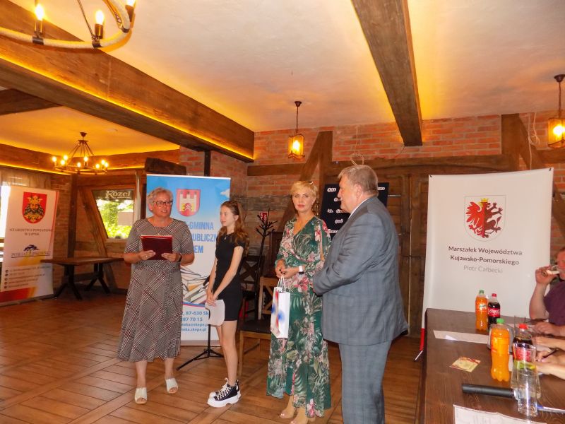 Fotografia przestawia moment wręczenia nagrody przez przedstawiciela Gminy Wielgie i  przedstawicieli samorządu województwa laureatce