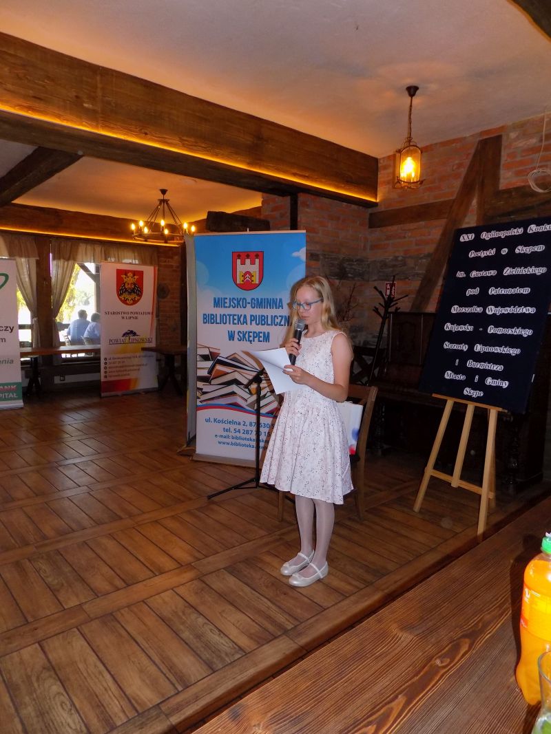 Fotografia przedstawia laureatkę czytającą nagrodzony wiersz. W sali, w której odbywa się gala konkursowa